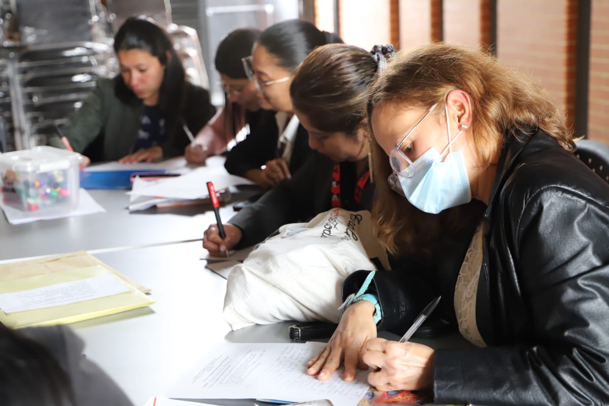 Foto de 5 profesoras tomando apuntes en sus libretas